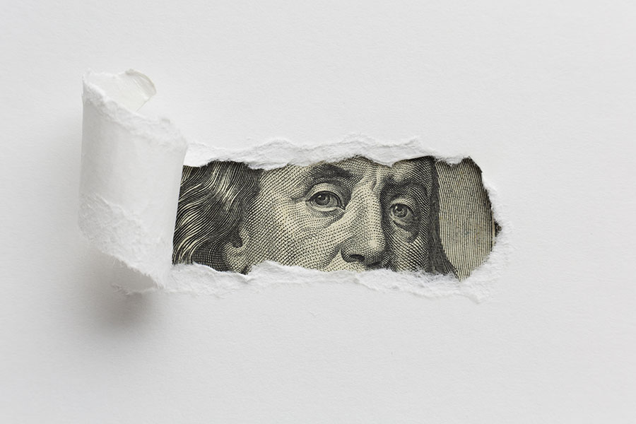 Imagem mostra nota de dólar com papel rasgado